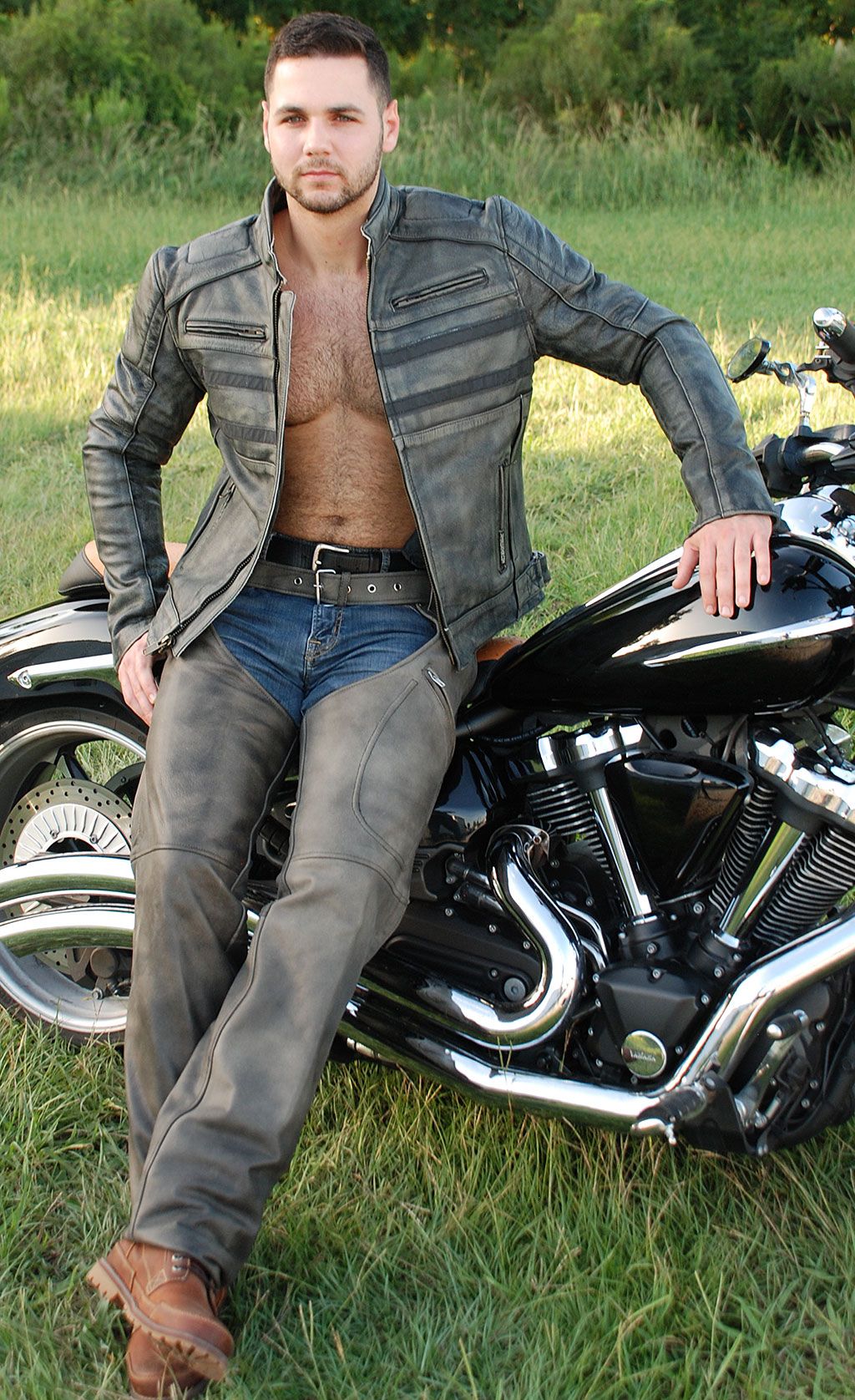Biker wearing vintage grey leather chaps with motorcycle